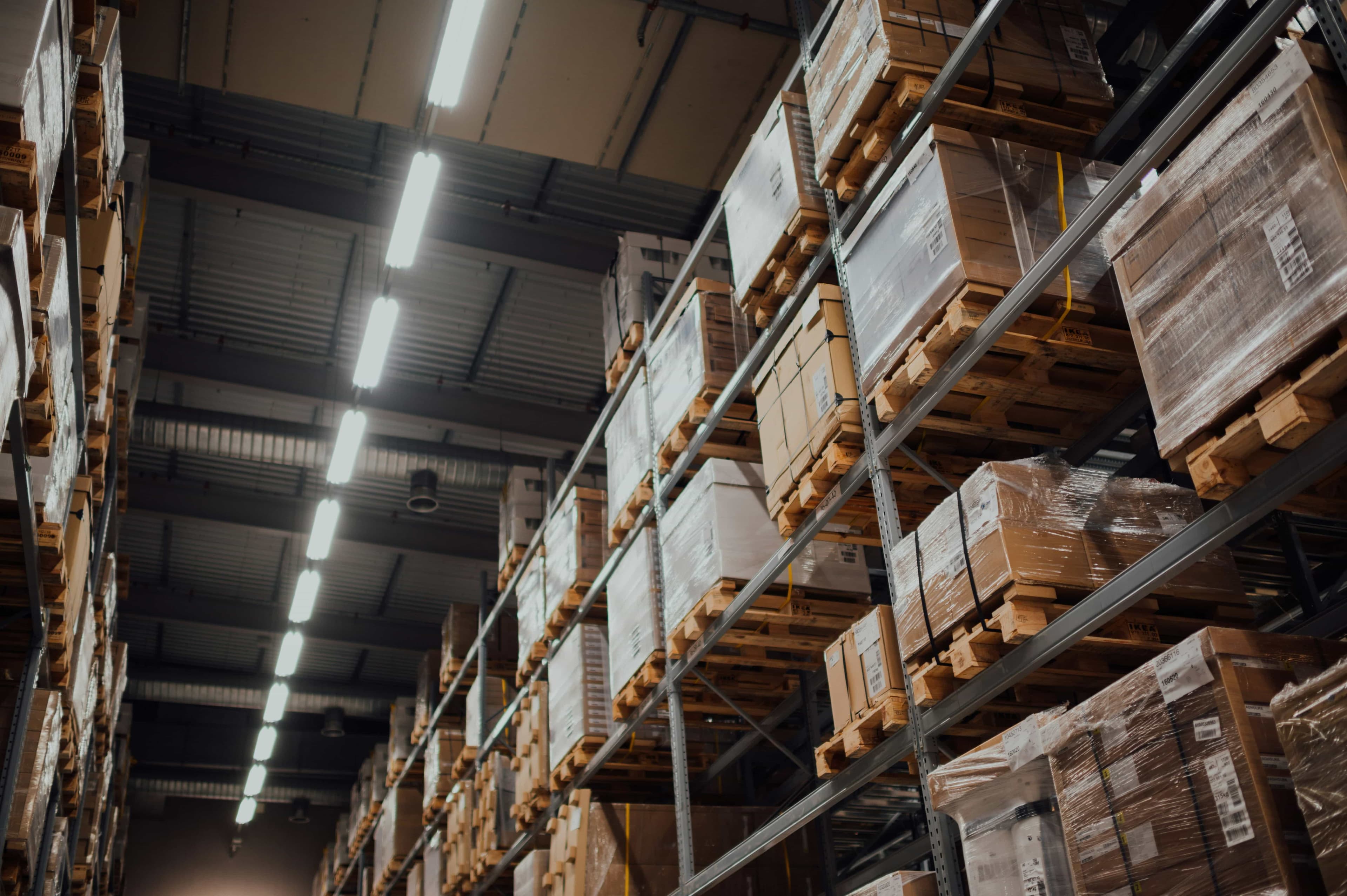 A warehouse with pallets and boxes, stacked up to the ceiling